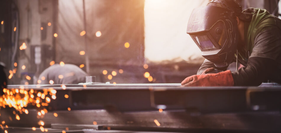 A,welder,with,a,welding,machine,works,in,a,factory