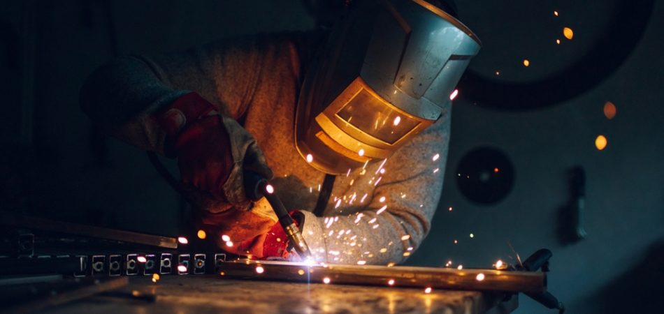 Man,worker,working,with,a,metal,product,and,welding,it